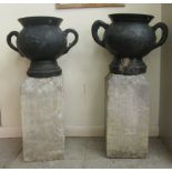 A pair of cast iron twin handled pedestal terrace vases of bulbous form, on associated plinths  40"h