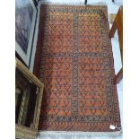 A Persian rug, decorated with repeating stylised designs, on a burnt orange ground  33" x 60"
