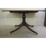 A Regency mahogany tip-top pedestal table, raised on splayed legs and brass cap casters  28"h  44"w