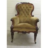 An early Victorian mahogany showwood framed salon chair with enclosed arms, part button