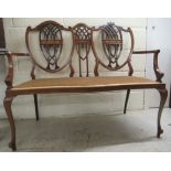 An Edwardian string inlaid mahogany framed twin shield and crossover splat double chairback settee