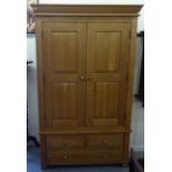 A modern light oak wardrobe with a pair of three-quarter height panelled doors, enclosing a