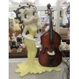 A Betty Boop composition figure, standing beside a cello which opens to contain CDs  36"h