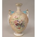 A Royal Worcester blush ivory glazed and gilded twin handled, ovoid shape vase, having a narrow