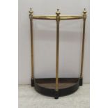 An early 20thC tubular lacquered brass, demi-lune stickstand with a shallow cast iron reservoir