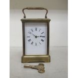An early 20thC lacquered brass carriage timepiece with bevelled glass panels; the movement faced