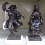 A pair of cast bronze figures, a man in 18thC costume, playing a fiddle and a dancing woman in a