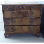 A George III walnut veneered dressing chest with three short/three long drawers, raised on bracket