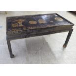 A mid 20thC Chinese inspired black lacquered and overpainted coffee table, raised on chamfered