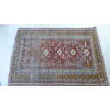 A Persian rug, decorated with stylised motifs, on a red and blue ground  50" x 70"