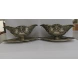 A pair of (possibly) Dutch white metal pedestal sauce boats, decorated with rams head, ribbon and