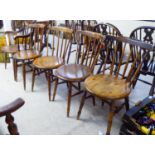 A matched set of six early 20thC beech and elm framed spindle back kitchen chairs, each with a solid