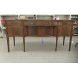 An early 20thC Regency style fan marquetry and string inlaid mahogany serpentine front sideboard,