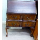 A 1920s/30s mahogany bureau with a fall front, over two serpentine front drawers, raised on cabriole