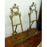 A pair of Victorian style cast brass, table top, easel stands, decorated with C-scrolls and