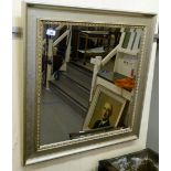 A modern bevelled mirror, set in a moulded, painted silver coloured frame  30" x 29"