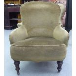 A late Victorian green fabric upholstered salon chair, raised on mahogany turned, tapered legs and