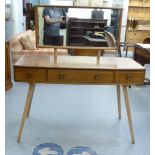 An Ercol light elm dressing table with a mirror, over three frieze drawers, raised on splayed