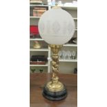 An antique style cast brass table lamp, featuring two standing figures, under a globe shade  26"h