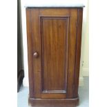 A late Victorian mahogany pot cupboard with a mottled grey marble top and a single, panelled door,