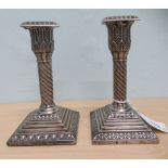 A pair of late Victorian loaded silver candlesticks with stiff leaf and spiralled decoration, each