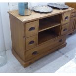 A modern waxed pine chest, comprising two tier open shelves, two short/one long drawer, raised on