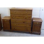 A modern waxed pine dressing chest with five long drawers and brass bun handles, raised on turned