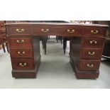 A late Victorian mahogany nine drawer twin pedestal desk, the top set with a tooled green scriber