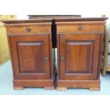 A pair of modern mahogany finished bedside cabinets, each with a drawer and panelled door, on a