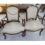 A pair of late 19thC French walnut showwood framed and upholstered open arm chairs with