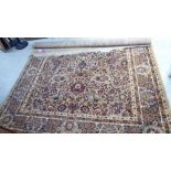 A Persian inspired machine made rug, profusely decorated with floral designs, on a multi-coloured