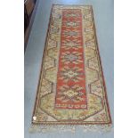 A Turkish woollen runner, decorated in colours with repeating stylised designs  105" x 33"