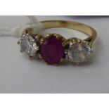 A 9ct gold ring, claw set with a central bevelled ruby, flanked by a pair of cubic zirconias