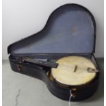 A vintage four string ukulele banjo, in a carrying case