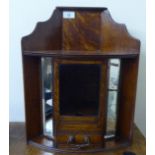 A 1920s oak hanging smokers corner cabinet with a lockable, bevelled glazed panelled door and a base