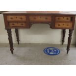 A late Victorian mahogany desk with five short drawers, raised on turned, tapered, fluted legs  30"h