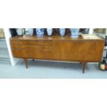 A 1970s teak sideboard with a bank of three offset, graduated drawers and a pair of adjacent