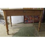 A late Victorian pine kitchen table with a frieze drawer, raised on turned, tapered legs  29"h  45"w