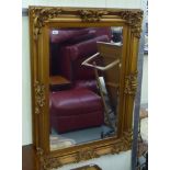 A modern mirror with a bevelled plate, set in an ornate gilt gesso frame  45" x 33"