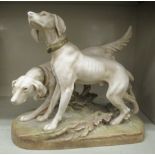 A Royal Dux satin glazed porcelain model, depicting two hounds, on a naturalistically moulded oval