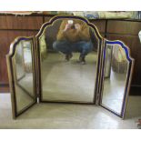 A late 19th/early 20thC triptych dressing mirror, the shaped plates set in moulded coloured glass