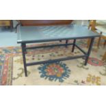 A modern two tone black/grey slate coffee table, the top with chessboard pattern, raised on square