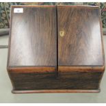 A late Victorian walnut desktop cabinet of angled form with a pair of hinged door, enclosing a