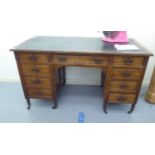 An early 20thC one piece mahogany, nine drawer, twin pedestal desk, raised on ring turned legs and