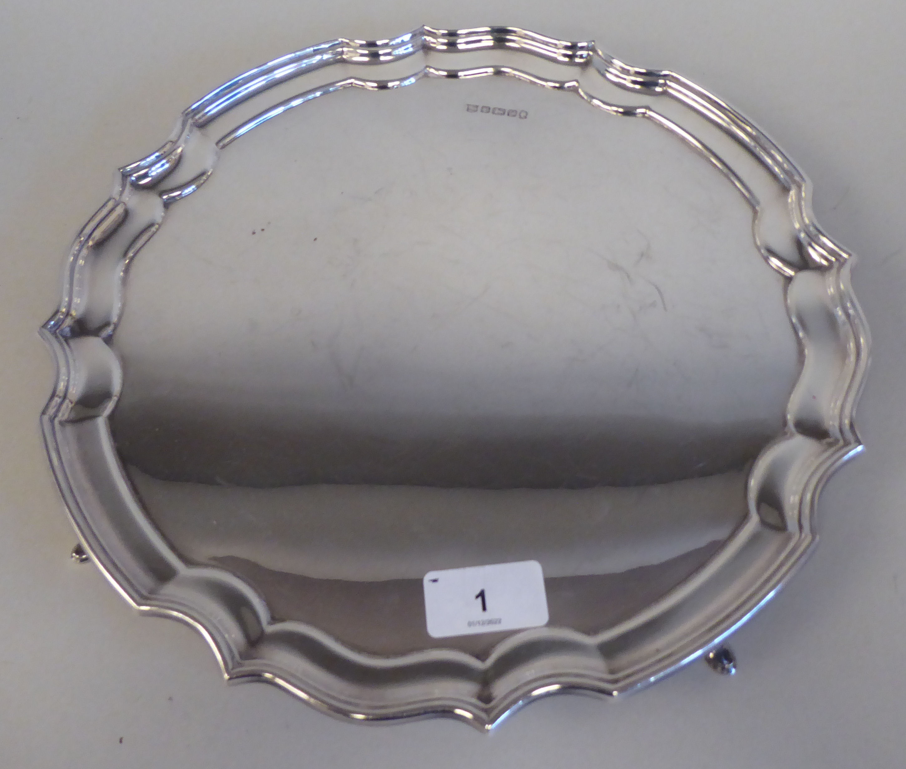 A Georgian style silver salver with a raised piecrust border, on pad feet  Peyton, Pepper & Sons