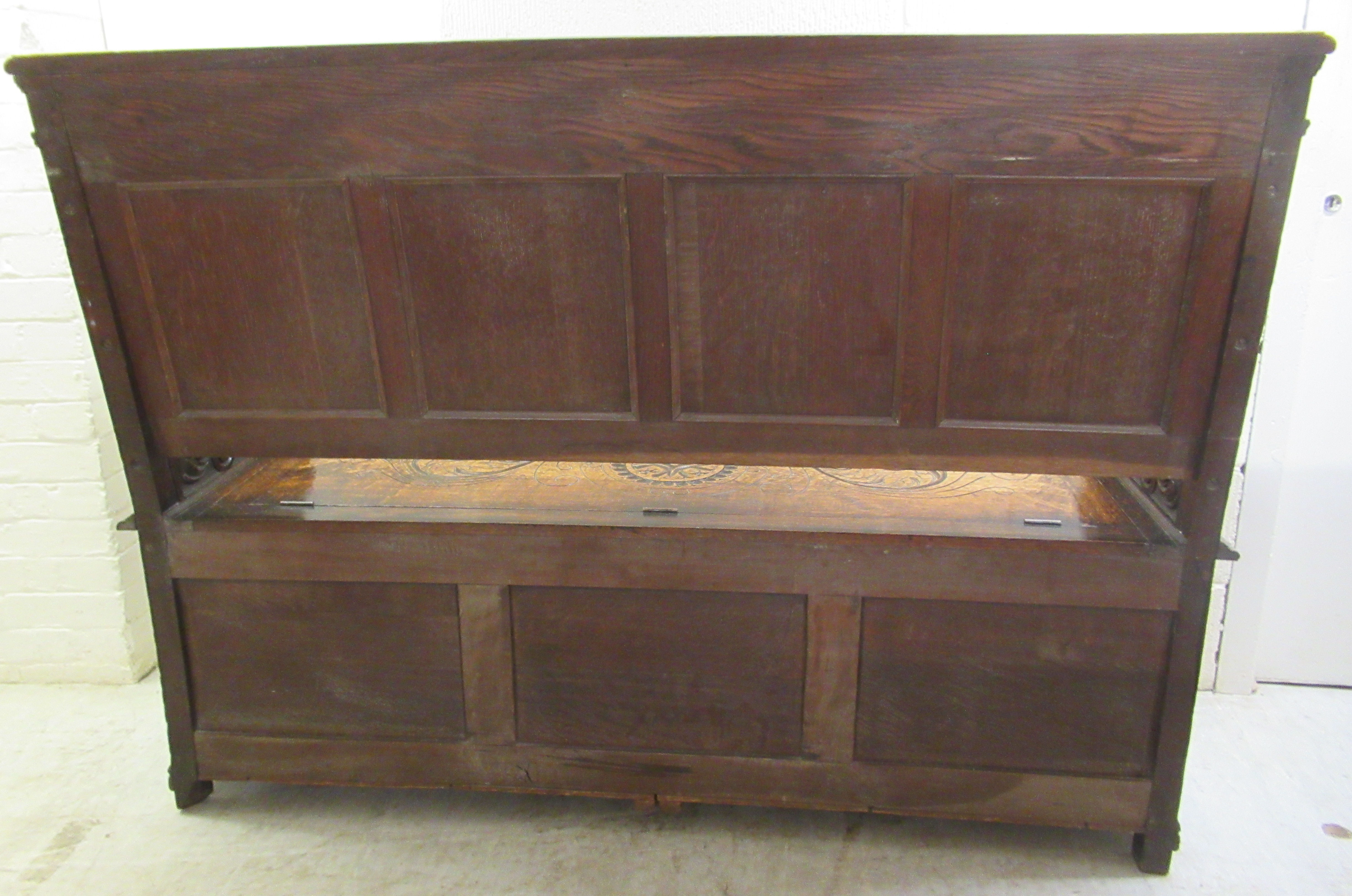 A late Victorian profusely carved oak settle with a high, level, quadruple fielded panelled back and - Image 7 of 7