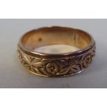 A 9ct gold wedding band ring with engraved rosette designs