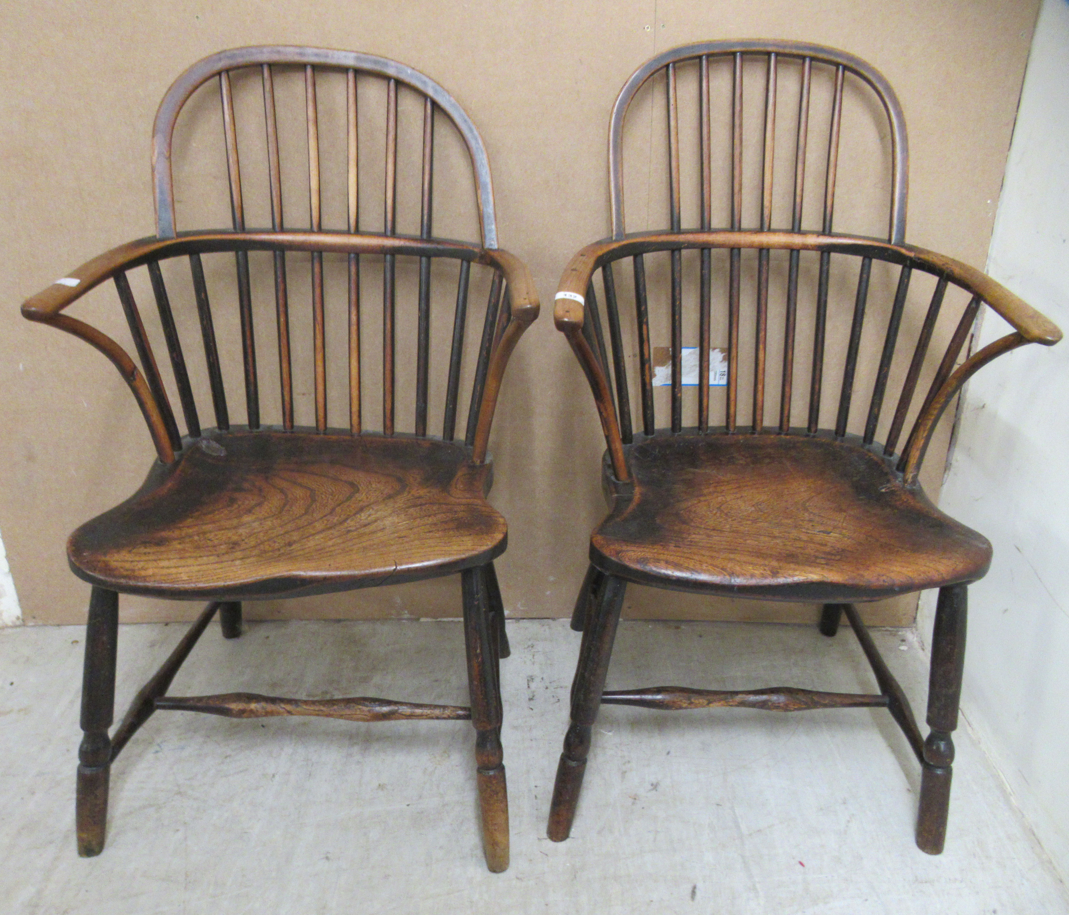 A matched pair of early 19thC beech and elm framed low hoop and spindled back Windsor elbow