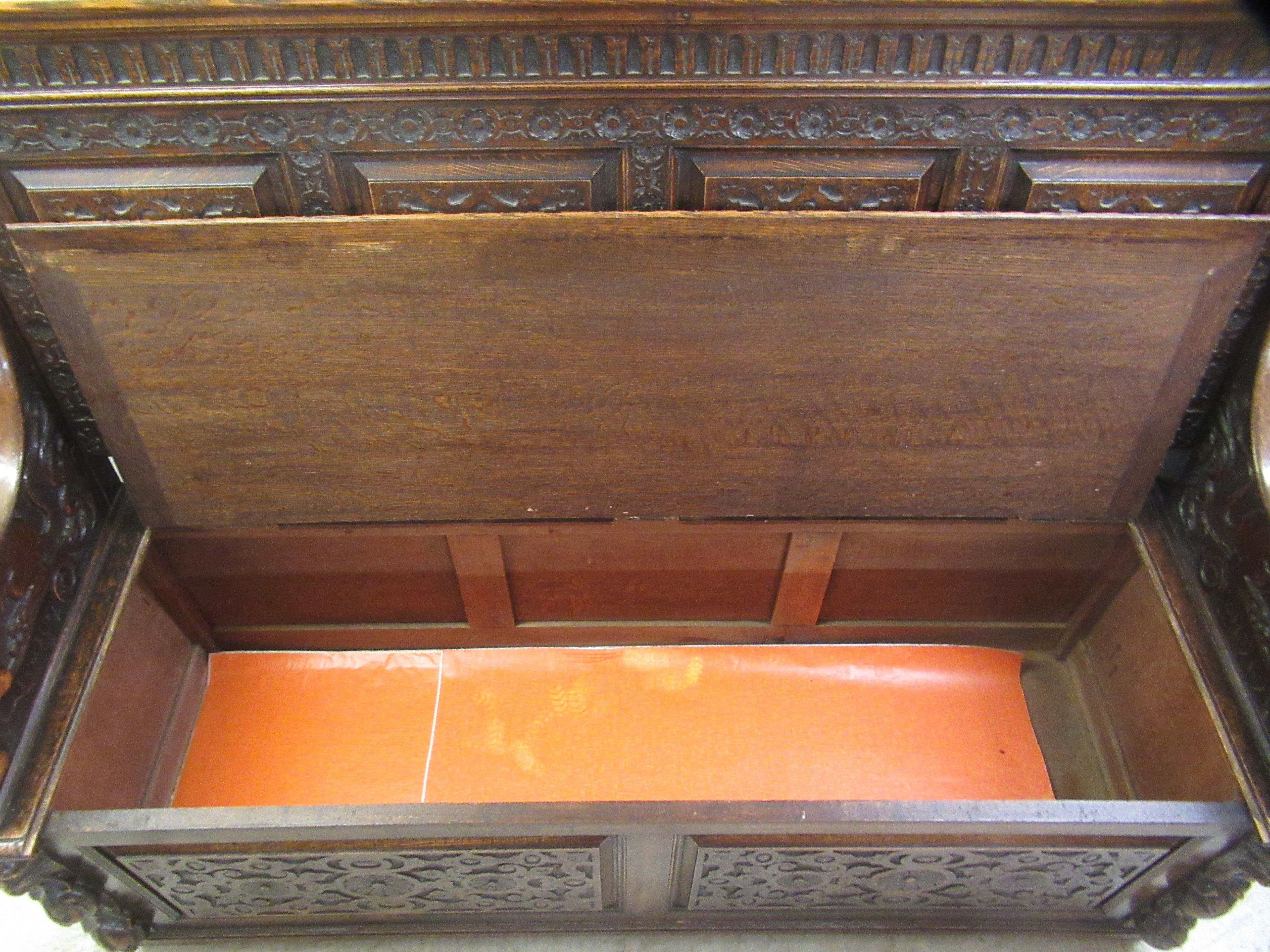 A late Victorian profusely carved oak settle with a high, level, quadruple fielded panelled back and - Image 5 of 7