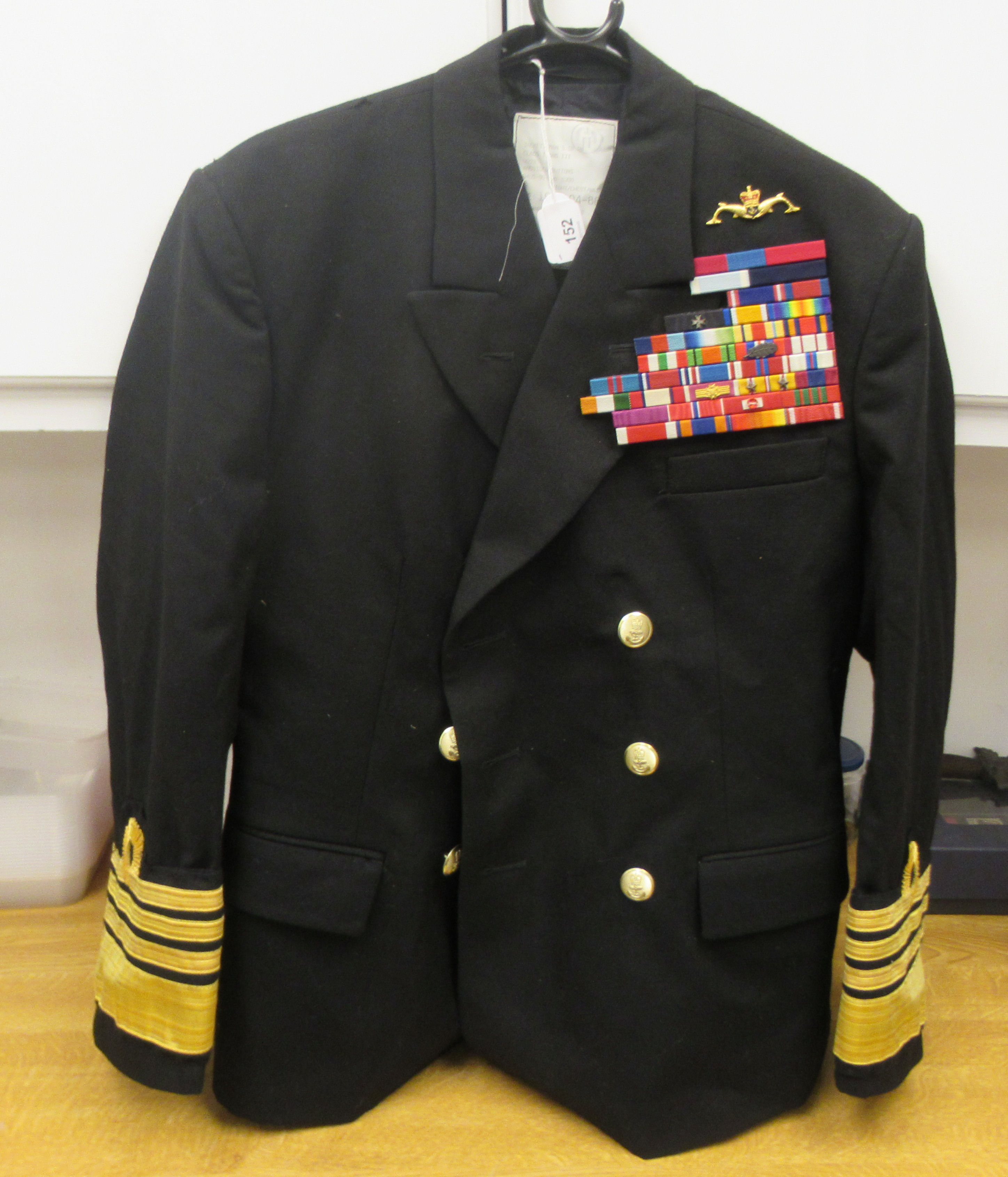 A Royal Navy submariners double-breasted tunic with emblems and braided sleeves, medal ribbons,